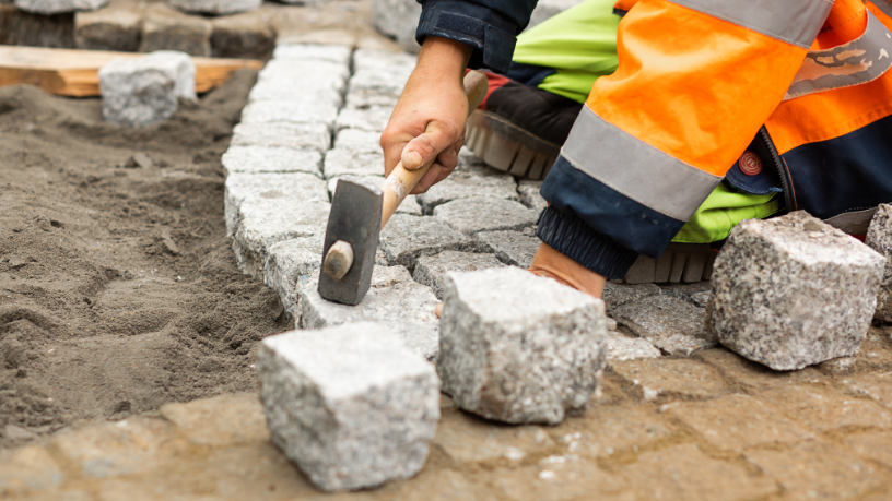 Guia prático sobre camada de assentamento do intertravado, destacando granulometria ideal e prevenção de deformações, com apoio técnico de Valderci Malagosini Machado.