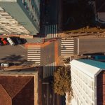Vista aérea de uma interseção urbana em Florianópolis, com ruas, edificações e veículos em circulação