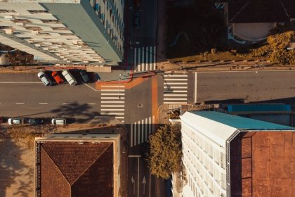 Vista aérea de uma interseção urbana em Florianópolis, com ruas, edificações e veículos em circulação