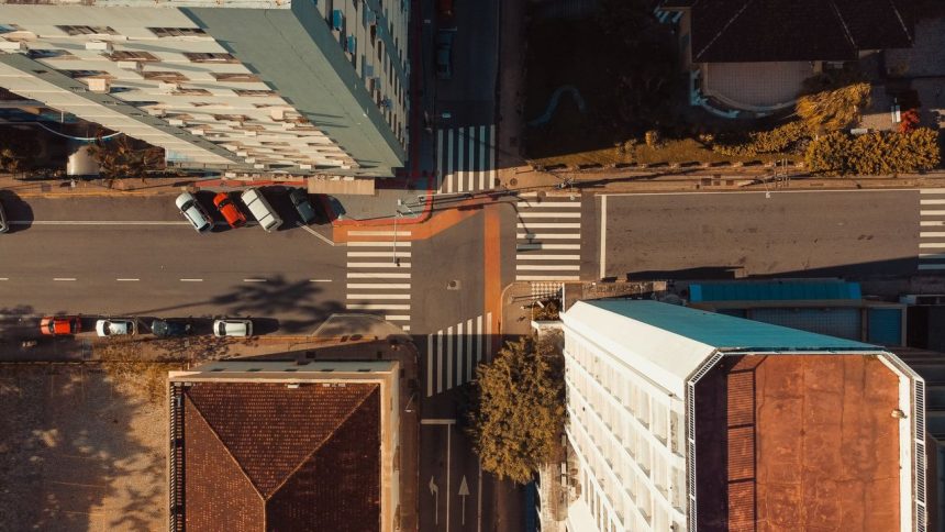 Vista aérea de uma interseção urbana em Florianópolis, com ruas, edificações e veículos em circulação