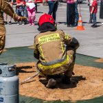 Bombeiros realizam uma demonstração de segurança com um botijão de gás diante do público.