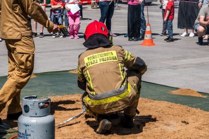 Bombeiros realizam uma demonstração de segurança com um botijão de gás diante do público.