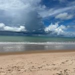 Praia de Tambaú, no Brasil, com ondas e nuvens carregadas sobre o litoral.