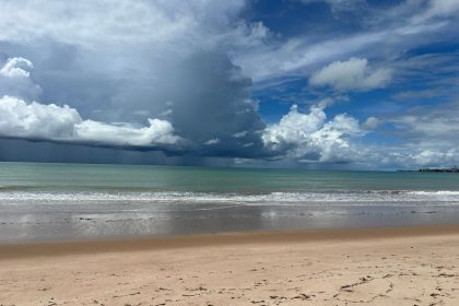Praia de Tambaú, no Brasil, com ondas e nuvens carregadas sobre o litoral.